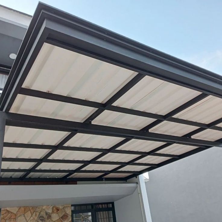 Kanopi baja kokoh dengan rangka baja tahan cuaca terpasang di area garasi rumah minimalis, solusi ideal menghadapi cuaca ekstrem – Jasa Pemasangan Rangka Baja WeldingNusantara.com
